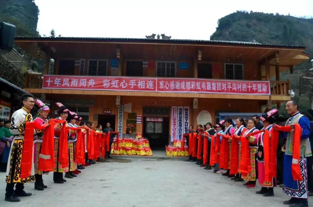懷感恩之心，平溝村村民手持羌紅在彩虹公司援建的平溝村便民服務(wù)樓前熱情等待彩虹親人們的到來(lái)